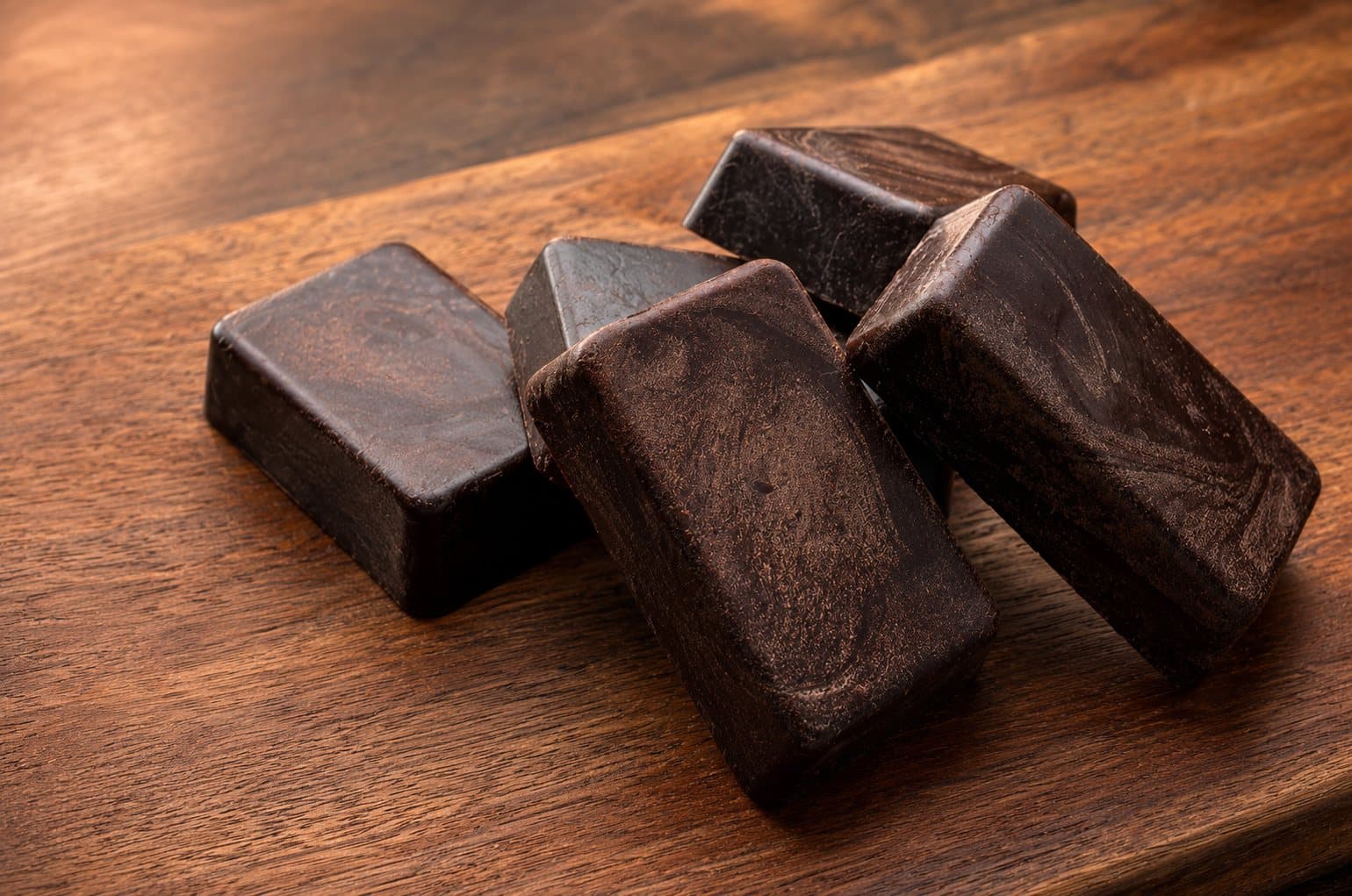 Blocks of Seven Sisters pure cacao on a dark wooden board